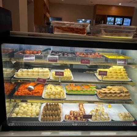 A cafe display cabinet stocked with fresh vegetarian Indian food